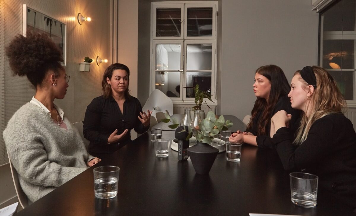 4 kvinnor pratar runt bord